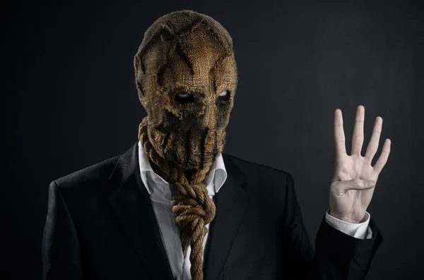 Fear and Halloween theme: a brutal killer in a mask on a dark background in the studio — Stok fotoğraf