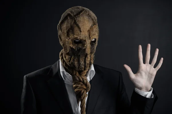 Fear and Halloween theme: a brutal killer in a mask on a dark background in the studio — Stok fotoğraf