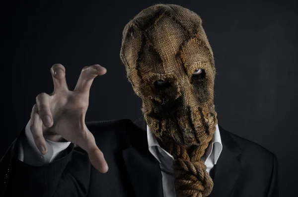 Fear and Halloween theme: a brutal killer in a mask on a dark background in the studio — Stok fotoğraf