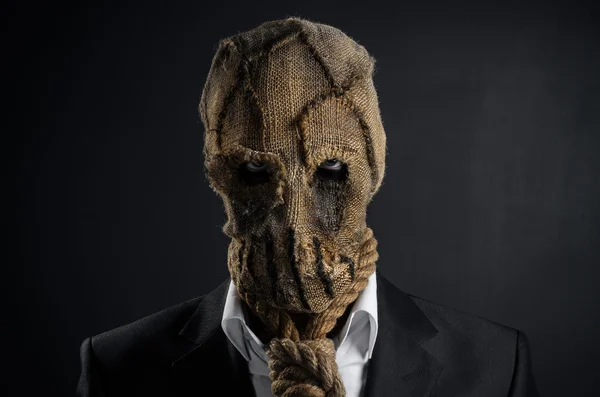 Fear and Halloween theme: a brutal killer in a mask on a dark background in the studio — Stok fotoğraf