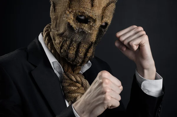 Fear and Halloween theme: a brutal killer in a mask on a dark background in the studio — Stockfoto