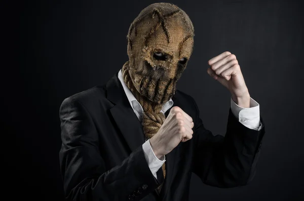 Fear and Halloween theme: a brutal killer in a mask on a dark background in the studio — Stockfoto