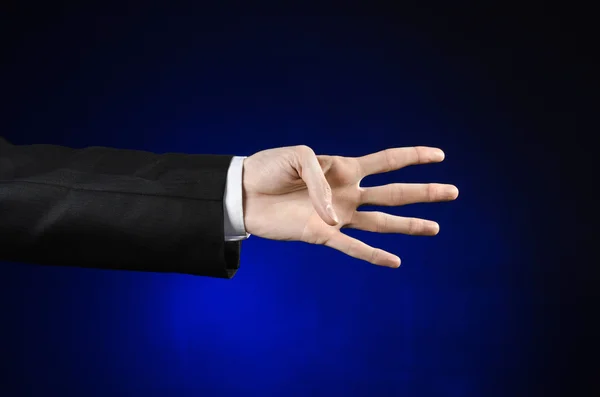 Tópico de homem de negócios e gesto: um homem de terno preto e camisa branca mostrando gesto de mão em um fundo azul escuro isolado em estúdio — Fotografia de Stock