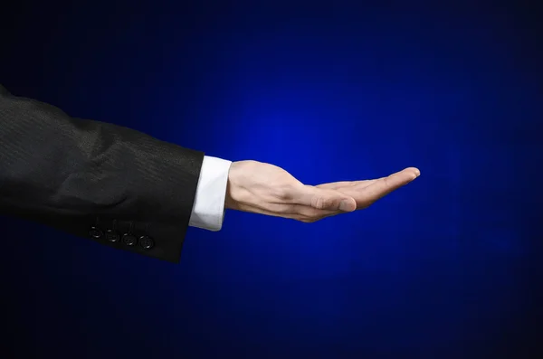 Uomo d'affari e tema del gesto: un uomo in abito nero e camicia bianca che mostra il gesto della mano su uno sfondo blu scuro isolato in studio — Foto Stock