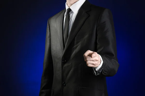 Tópico de homem de negócios e gesto: um homem de terno preto e camisa branca mostra sua mão para a frente em um fundo azul escuro em estúdio isolado — Fotografia de Stock