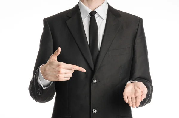 Businessman and gesture topic: a man in a black suit with a tie shows the right hand index finger on his left hand on an isolated white background in studio — 스톡 사진