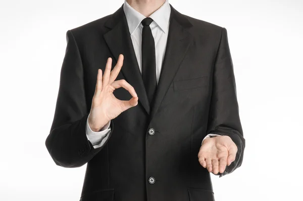 Businessman and gesture topic: a man in a black suit with a tie showing okay sign with his left hand and holds his right hand on a white isolated background in studio — 스톡 사진