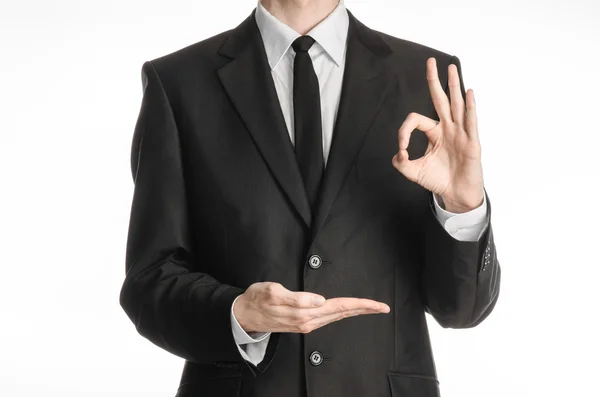 Businessman and gesture topic: a man in a black suit with a tie showing okay sign with his left hand and holds his right hand on a white isolated background in studio — Stock Photo, Image