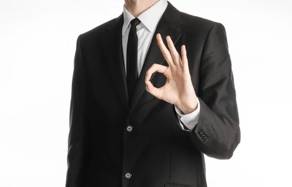 Businessman and gesture topic: a man in a black suit with a tie showing okay hand gestur on an isolated white background in studio — Stok Foto