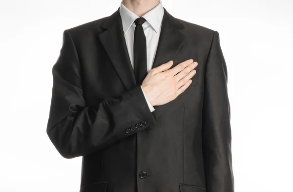 Businessman and gesture topic: a man in a black suit with a tie put his hand on his chest isolated on white background in studio — 图库照片