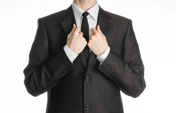 Businessman and gesture topic: a man in a black suit with a tie straightens his tie isolated on white background in studio — Stock Photo, Image