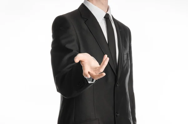 Businessman and gesture topic: a man in a black suit and tie holds out his hand isolated on a white background in studio — Stock Photo, Image