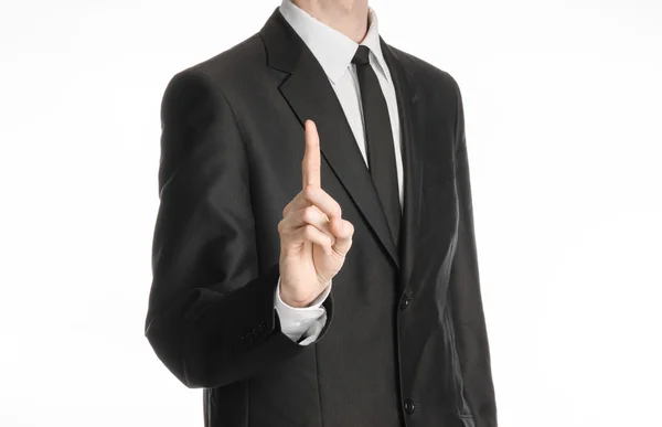 Businessman and gesture topic: a man in a black suit with a tie shows an index finger upward on white isolated background in studio — 스톡 사진