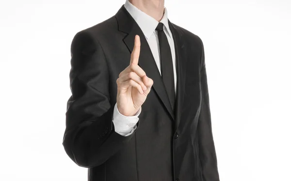 Businessman and gesture topic: a man in a black suit with a tie shows an index finger upward on white isolated background in studio — Stock Photo, Image