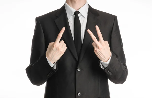 Businessman and gesture topic: a man in a black suit with a tie showing a sign with his right hand and the left hand sign two on the white isolated background in studio — 스톡 사진