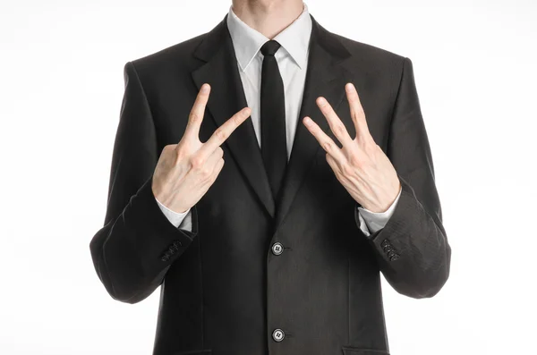 Businessman and gesture topic: a man in a black suit with a tie showing a sign with his right hand two or three left hand sign isolated on white background in studio — Stock Photo, Image