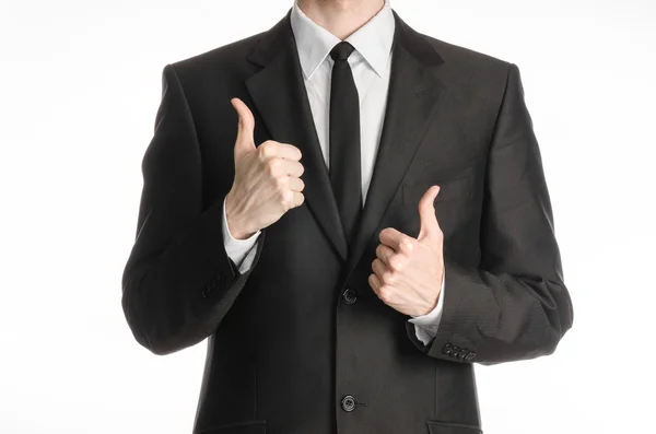 Бізнесмен і тема жесту: чоловік у чорному костюмі з краваткою, що показує два пальці вгору ізольовані на білому тлі в студії — стокове фото