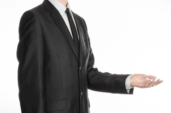 Businessman and gesture topic: a man in a black suit and tie holding his hand in front of him isolated on a white background in studio — Stok fotoğraf