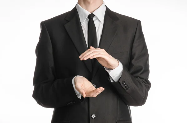 Businessman and gesture topic: a man in a black suit and tie holding hands in front isolated on white background in studio — Stockfoto