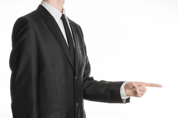 Businessman and gesture topic: a man in a black suit and tie holding his hand in front of him and shows his index finger isolated on white background in studio — Zdjęcie stockowe