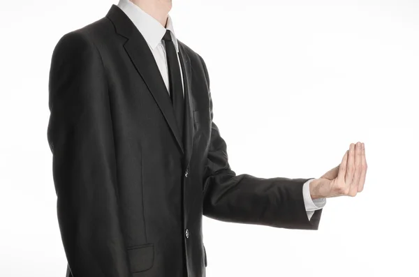 Бізнесмен і тема жесту: чоловік в чорному костюмі і краватка тримає руку перед собою і показує жест щіпки на ізольованому білому тлі в студії — стокове фото