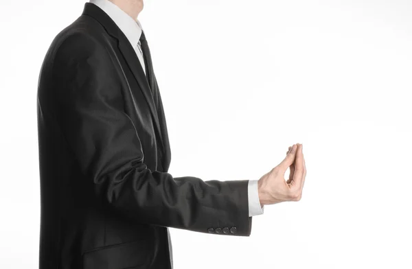 Businessman and gesture topic: a man in a black suit and tie holding his hand in front of him and shows a pinch gesture on an isolated white background in studio — Stock Photo, Image