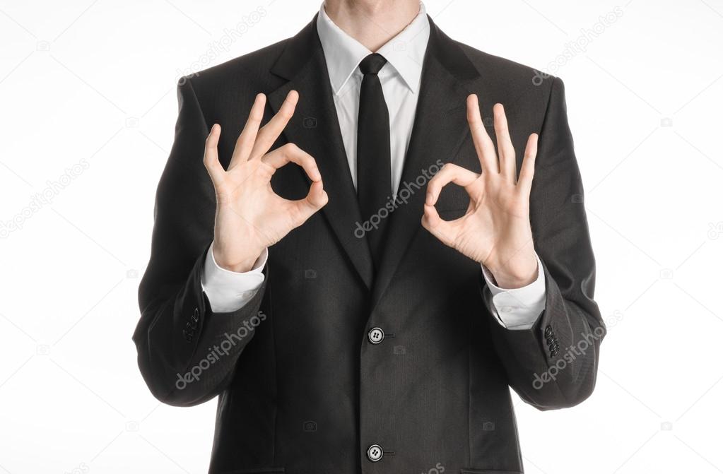 Businessman and gesture topic: a man in a black suit with a tie showing two hands sign of okay isolated on white background in studio