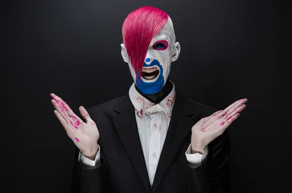 Clown and Halloween theme: Scary clown with pink hair in a black jacket on a dark background in the studio — 图库照片