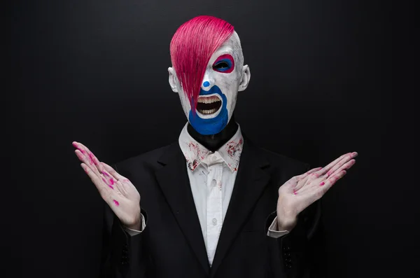 Clown and Halloween theme: Scary clown with pink hair in a black jacket on a dark background in the studio — 图库照片