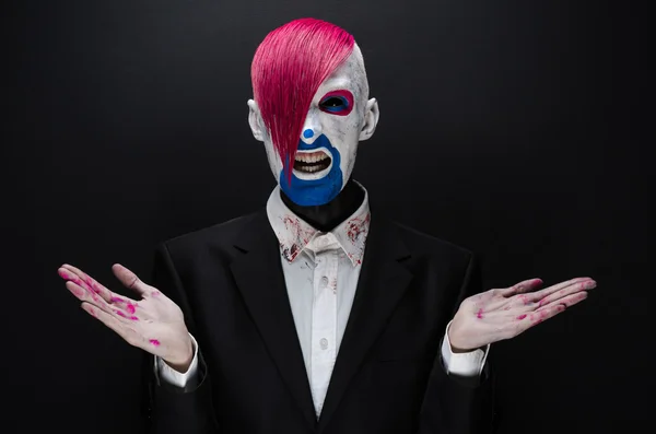 Clown and Halloween theme: Scary clown with pink hair in a black jacket on a dark background in the studio — 图库照片