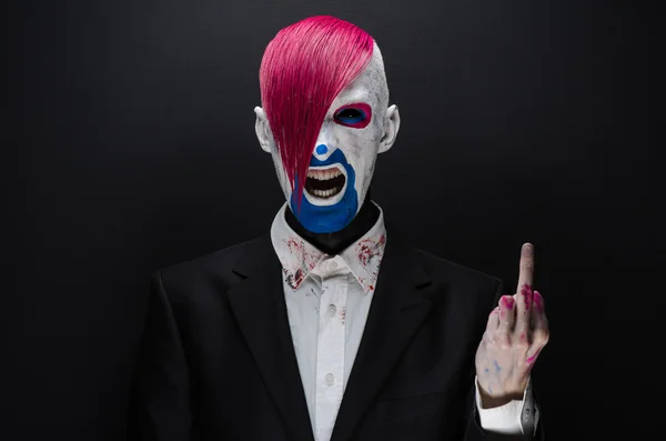 Clown and Halloween theme: Scary clown with pink hair in a black jacket on a dark background in the studio — Stok fotoğraf
