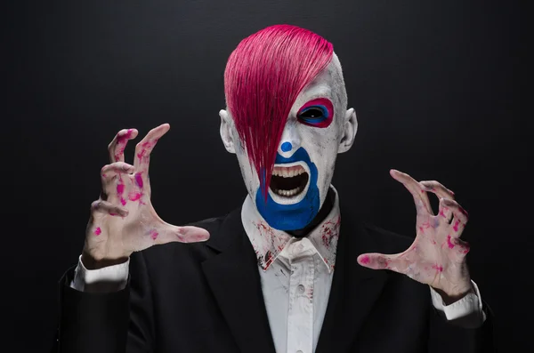 Clown and Halloween theme: Scary clown with pink hair in a black jacket on a dark background in the studio — 图库照片