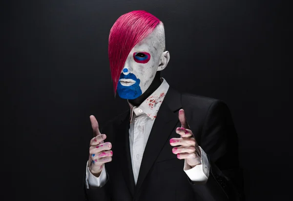 Clown and Halloween theme: Scary clown with pink hair in a black jacket on a dark background in the studio — 图库照片