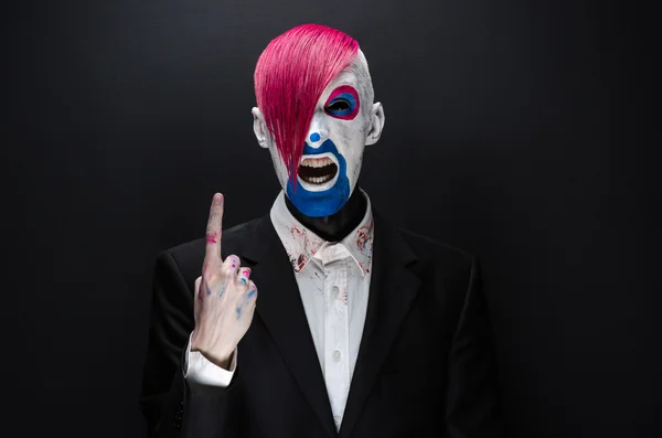 Clown and Halloween theme: Scary clown with pink hair in a black jacket on a dark background in the studio — Stok fotoğraf