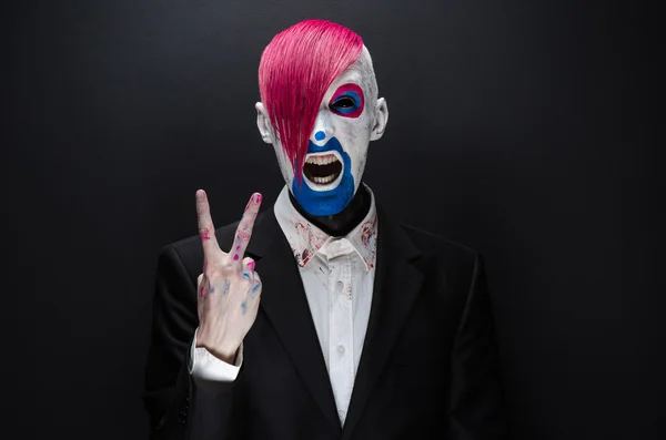 Clown and Halloween theme: Scary clown with pink hair in a black jacket on a dark background in the studio — 图库照片