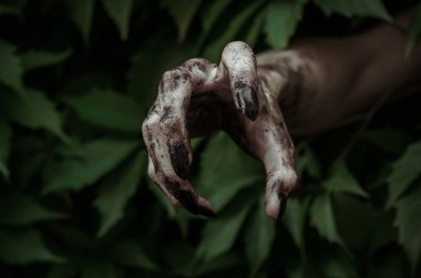 Korku ve Halloween Tema: korkunç kirli el ile siyah tırnak zombi ölü kıyamet yürüyüş yeşil yaprakları dışarı tarar