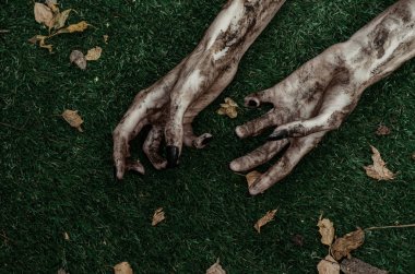 Korku ve Halloween Tema: korkunç zombi eller siyah çivi yalan yeşil çimen, yürüyen ölü kıyamet üzerine kirli, ana sayfa görünümü