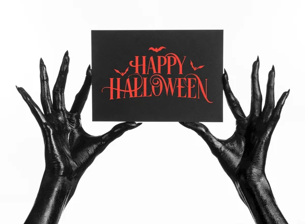 Postcard and Happy Halloween theme: black hand of death holding a paper card with the words Happy Halloween on a white isolated background in studio — Stock Photo, Image