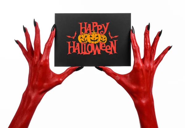 Postcard and Happy Halloween theme: red devil hand with black nails holding a paper card with the words Happy Halloween on a white isolated background in studio — Stockfoto