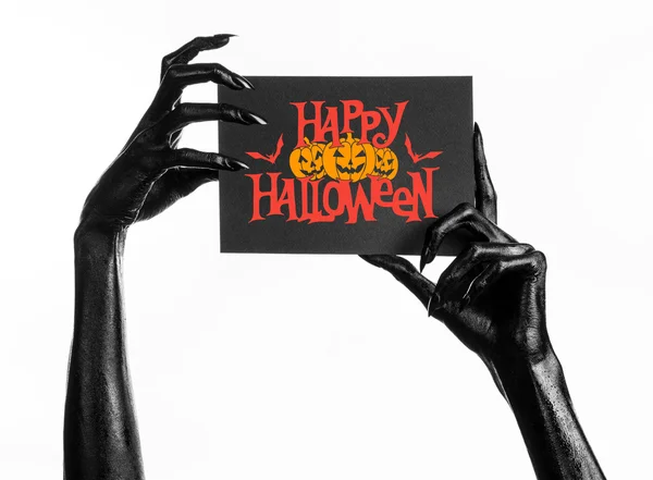 Postkarte und Happy-Halloween-Thema: Schwarze Hand des Todes hält eine Papierkarte mit den Worten Happy-Halloween auf weißem, isoliertem Hintergrund im Studio — Stockfoto