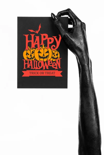 Briefkaart en Happy Halloween thema: zwarte hand van de dood met een papieren kaart met de woorden Happy Halloween op een witte achtergrond in studio geïsoleerd — Stockfoto