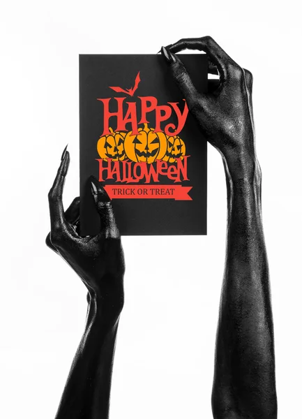 Briefkaart en Happy Halloween thema: zwarte hand van de dood met een papieren kaart met de woorden Happy Halloween op een witte achtergrond in studio geïsoleerd — Stockfoto