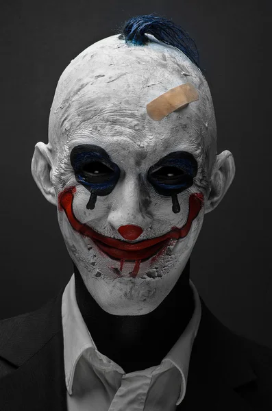 Korkunç palyaço ve Halloween Tema: izole stüdyoda karanlık bir arka plan üzerinde siyah elbiseli çılgın korkunç mavi palyaço