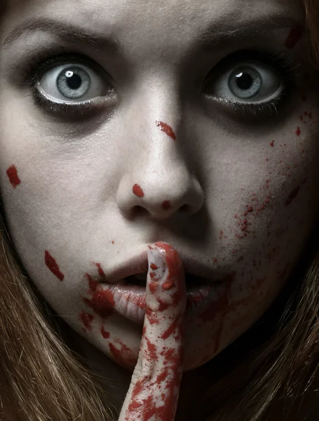 Scary Girl and Halloween theme: portrait of a crazy girl with a bloody face in the studio — Stok fotoğraf