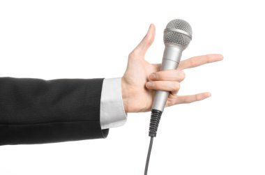 İş ve konuşma konu: Studio izole bir beyaz zemin üzerinde gri bir mikrofon tutan siyah elbiseli adam