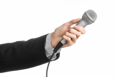 İş ve konuşma konu: Studio izole bir beyaz zemin üzerinde gri bir mikrofon tutan siyah elbiseli adam