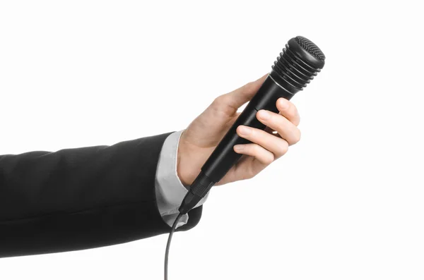 Geschäfts- und Redethema: Mann im schwarzen Anzug hält ein schwarzes Mikrofon isoliert auf weißem Hintergrund im Studio — Stockfoto