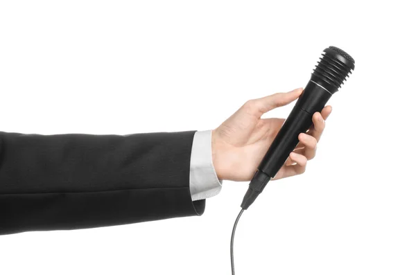 Affärs- och tal ämne: mannen i svart kostym innehar en svart mikrofon isolerad på vit bakgrund i studio — Stockfoto