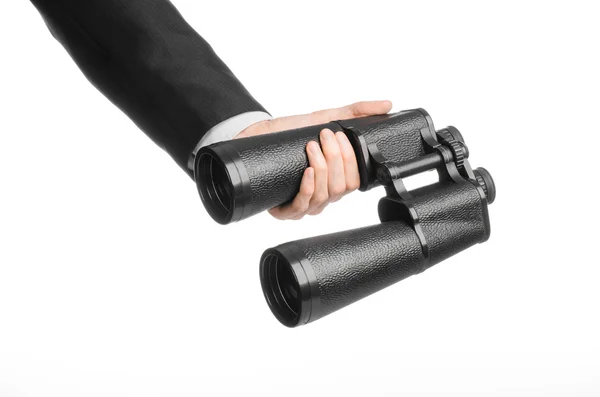 Business and search topic: Man in black suit holding a black binoculars in hand on white isolated background in studio — 图库照片