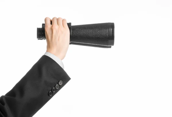 Business and search topic: Man in black suit holding a black binoculars in hand on white isolated background in studio — 스톡 사진